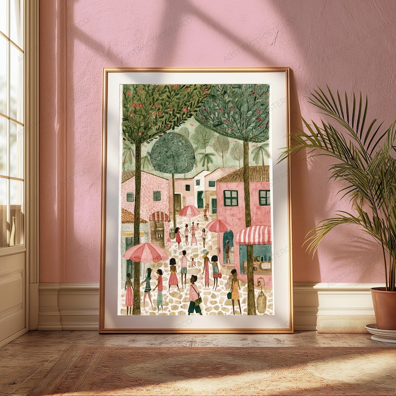 May include: A framed vertical art print depicting a bustling town square with pink buildings, tall green trees, and people walking on a cobblestone path. Several pink and white striped umbrellas are scattered throughout the scene under a soft light.