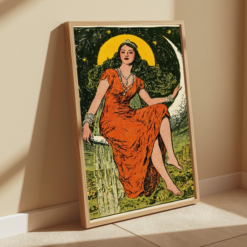 May include: A framed art print featuring a person with long dark hair wearing a vibrant orange dress and a silver necklace, seated on a large crescent moon against a dark green starry sky with a yellow circular backdrop and a landscape below.