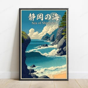 Puede incluir: Una impresi&oacute;n art&iacute;stica enmarcada que muestra un paisaje costero con olas azules rompiendo contra acantilados rocosos oscuros, una playa de arena y nubes blancas en un cielo azul. El texto en la parte superior dice 静岡の海 y Sea of Shizuoka.