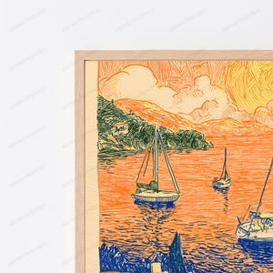 May include: A framed art print featuring a stylized coastal scene with sailboats on orange water. The illustration uses bold, hatched lines in shades of orange, yellow, and dark blue to depict hills, clouds, and boats under a warm, vibrant sky.