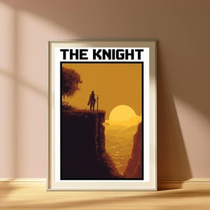 May include: A framed wall art print titled THE KNIGHT, featuring a pixel art illustration of a lone figure standing on a cliff edge with a sword at sunset. The scene uses shades of orange and dark brown, depicting a silhouette against a large sun.