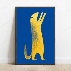 K&ouml;nnte beinhalten: Ein gerahmter, rechteckiger Wandkunstdruck mit einem stilisierten gelben Erdm&auml;nnchen, das auf seinen Hinterbeinen steht und die Vorderpfoten vor einem einfarbigen, tiefblauen Hintergrund hebt. Das Erdm&auml;nnchen hat eine k&ouml;rnige Textur in Goldgelb.