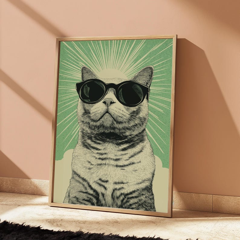 Puede incluir: Una l&aacute;mina de arte mural rectangular con una ilustraci&oacute;n detallada de un gato con gafas de sol negras. El gato est&aacute; centrado sobre un fondo verde claro con l&iacute;neas de rayos de sol y una base de color crema, todo dentro de un marco de madera.