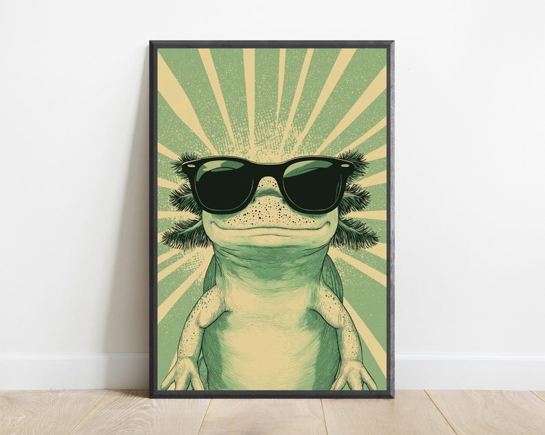 Puede incluir: Una impresi&oacute;n de arte mural enmarcada que muestra un ajolote verde con gafas de sol negras. El ajolote est&aacute; centrado sobre un fondo de rayos de sol de color verde claro y crema, creando una ilustraci&oacute;n gr&aacute;fica audaz en un marco negro.