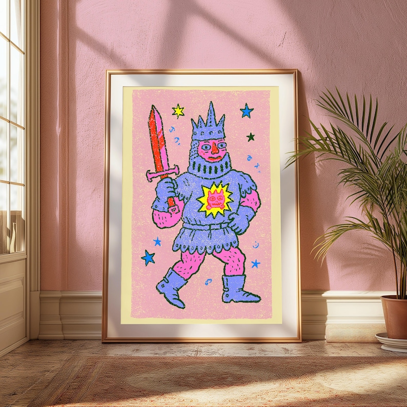 May include: A framed art print featuring a stylized illustration of a knight in blue armor and a crown, holding a red sword. The figure has pink skin and stands against a textured pink background with scattered blue and yellow stars.