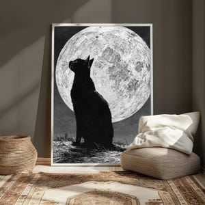 May include: A rectangular wall art print featuring a black cat silhouette sitting in profile, looking up at a large, textured white full moon against a dark, starry night sky. The artwork is rendered in a high-contrast black and white style.