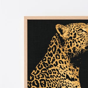 Peut inclure: Une &oelig;uvre d'art murale encadr&eacute;e repr&eacute;sentant un l&eacute;opard dor&eacute; avec des taches noires sur un fond noir uni. Le l&eacute;opard est repr&eacute;sent&eacute; de profil, tourn&eacute; vers la droite, avec un aspect textur&eacute;. L'&oelig;uvre est ins&eacute;r&eacute;e dans un cadre en bois clair.