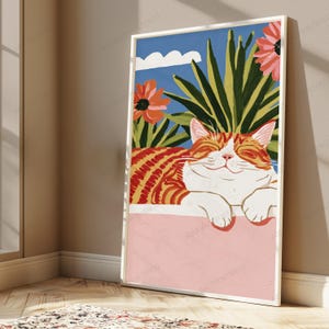 Puede incluir: Una impresi&oacute;n de arte mural rectangular que presenta un gato atigrado naranja estilizado con los ojos cerrados descansando sobre una repisa rosa. El fondo muestra plantas verdes puntiagudas, dos flores grandes color coral y una nube blanca.
