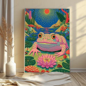 May include: A vibrant art print featuring a large, pink, spotted frog sitting in a pond surrounded by green lily pads, a blooming pink lotus flower, red mushrooms, and a stylized sun in a deep blue sky with yellow dots representing light.