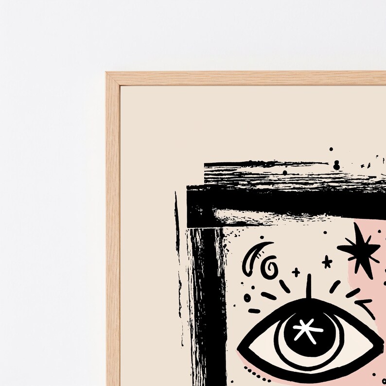 Peut inclure: Une impression d'art encadr&eacute;e pr&eacute;sentant une illustration &agrave; l'encre noire sur fond beige clair. Le motif comprend un &oelig;il stylis&eacute; avec une &eacute;toile au centre, entour&eacute; de symboles c&eacute;lestes comme des &eacute;toiles et un croissant de lune, le tout encadr&eacute; par une bordure rectangulaire noire &eacute;paisse et textur&eacute;e.