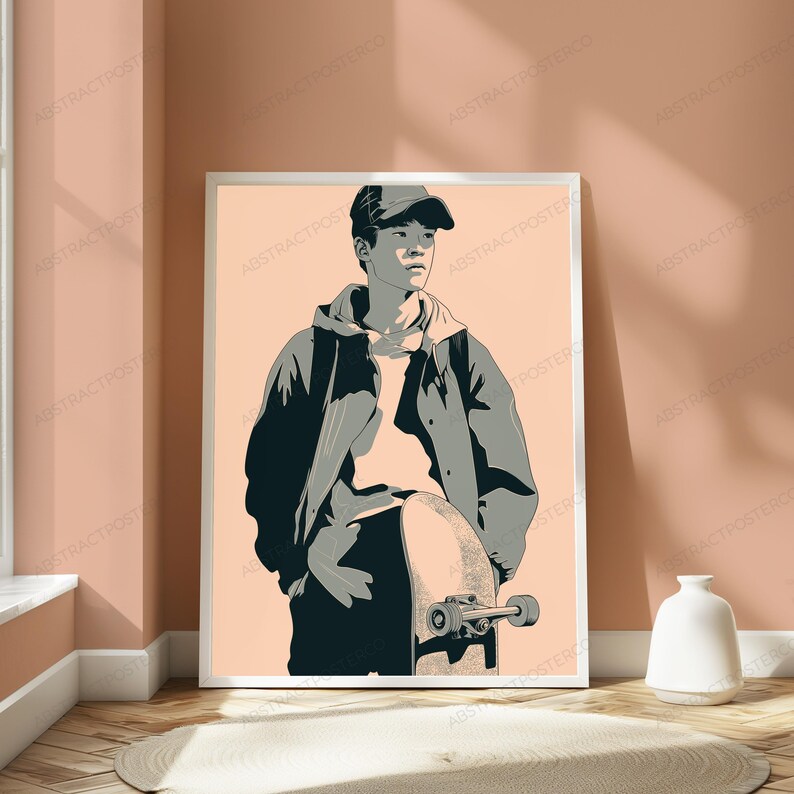 Puede incluir: Una l&aacute;mina de arte mural enmarcada que presenta la ilustraci&oacute;n estilizada de una persona con gorra de b&eacute;isbol y chaqueta con capucha, de pie mientras sostiene un monopat&iacute;n. La obra utiliza una paleta de tonos melocot&oacute;n, gris oscuro y gris claro.