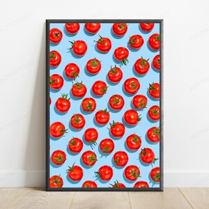 May include: A framed vertical poster featuring a repeating pattern of bright red tomatoes on a light blue background. The tomatoes are arranged in a grid-like layout, each showing green stems and a smooth, round surface, enclosed in a thin black frame.