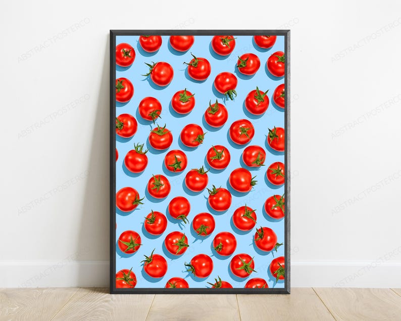 May include: A framed vertical poster featuring a repeating pattern of bright red tomatoes on a light blue background. The tomatoes are arranged in a grid-like layout, each showing green stems and a smooth, round surface, enclosed in a thin black frame.