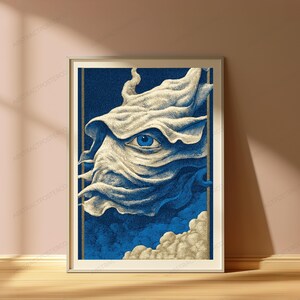 May include: A framed art print featuring a stylized illustration of a single blue eye emerging from swirling, cream-colored fabric-like clouds against a deep blue background, enclosed within a thin gold border and a simple light-colored frame.