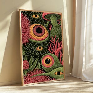 May include: A rectangular framed wall art print featuring a dense, surreal illustration with multiple large, wide-open eyes, textured green organic shapes, pink spiky floral elements, and mushroom-like structures on a dark black background.