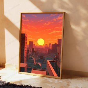 May include: A rectangular framed wall art print featuring a vibrant sunset over a dense city skyline. The sky is a gradient of bright orange and red with scattered clouds. The buildings are depicted in dark silhouettes against the glowing sun.