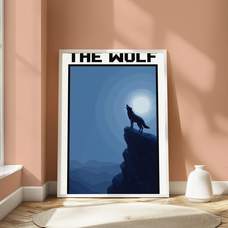 May include: A framed wall art print featuring a dark blue silhouette of a wolf howling at a full moon atop a jagged cliff. The text THE WOLF is printed in a black pixelated font at the top of the white-bordered rectangular poster.
