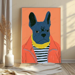 May include: A framed wall art print featuring a stylized illustration of a dark blue French Bulldog wearing a yellow turtleneck sweater under an orange jacket against a solid orange background. The dog has large ears and a serious expression.