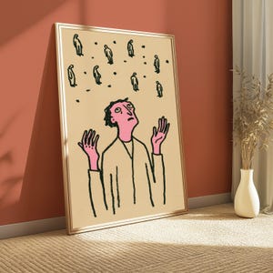 Op de afbeelding: Een ingelijste kunstdruk met een lijntekening van een persoon met een roze huid en donker haar die met opgeheven handen omhoog kijkt. Boven de persoon staan verschillende kleine, donkere, gestileerde figuren en stippen op een beige achtergrond.