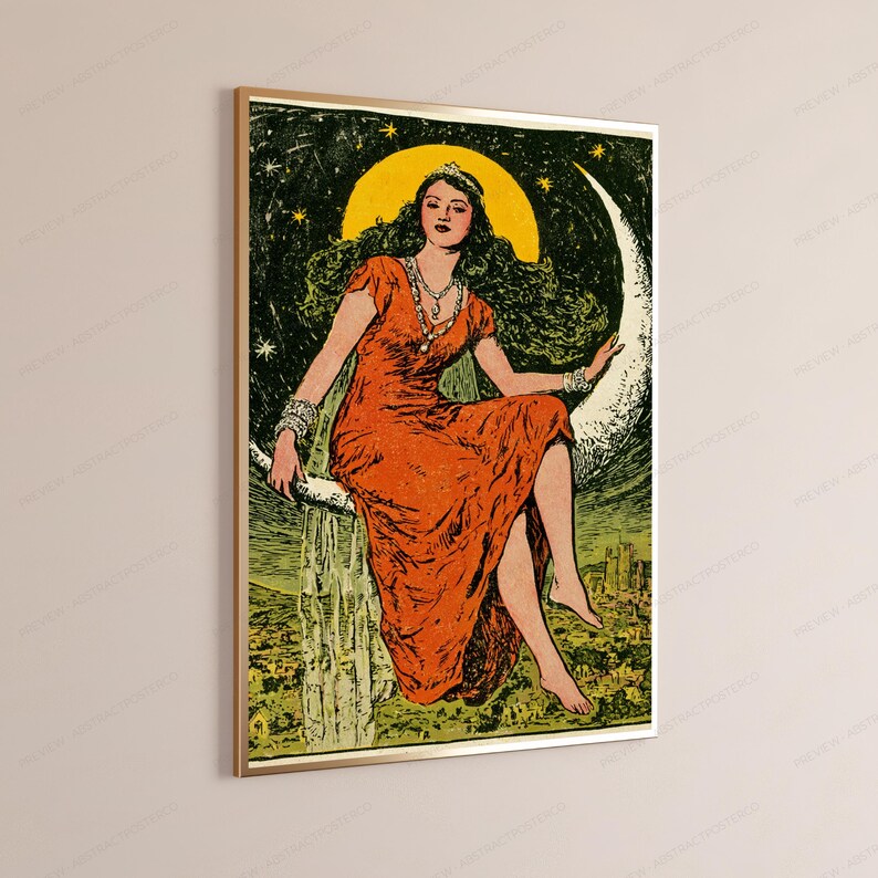 May include: A framed wall art print featuring a person with long dark hair wearing a vibrant orange dress and a silver necklace, sitting on a large white crescent moon against a dark green starry night sky above a landscape with buildings.