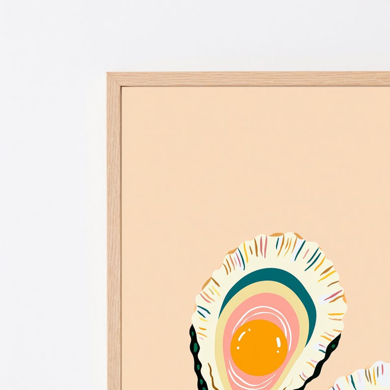K&ouml;nnte beinhalten: Ein gerahmter Kunstdruck mit einer stilisierten Illustration einer ge&ouml;ffneten Austernschale auf hellpfirsichfarbenem Hintergrund. Das Innere der Schale zeigt konzentrische Schichten in Creme, Petrol und Rosa mit einer leuchtend orangen Perle.