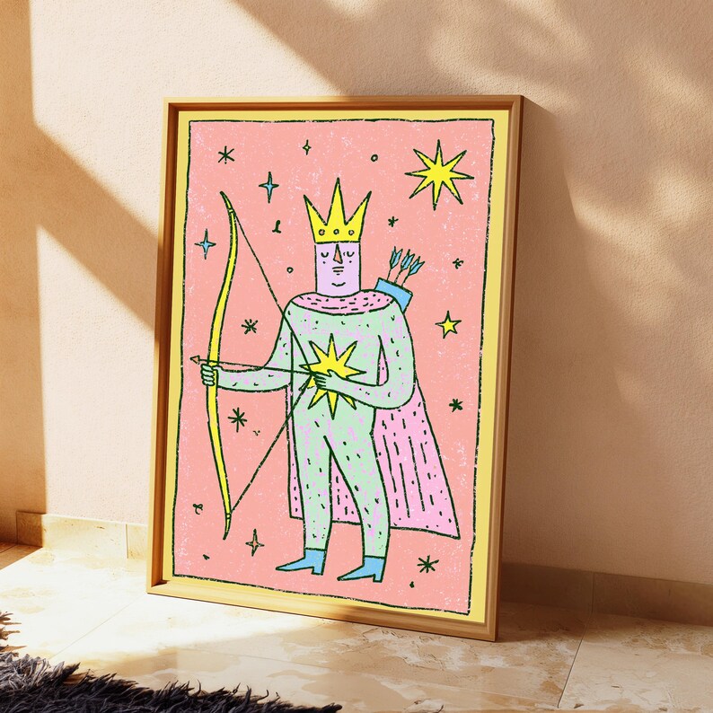K&ouml;nnte beinhalten: Ein gerahmter rechteckiger Wandkunstdruck mit einer stilisierten Figur, die eine gelbe Krone und ein hellgr&uuml;nes Outfit mit einem rosa Umhang tr&auml;gt. Die Figur h&auml;lt einen gelben Bogen und Pfeil vor einem rosa Hintergrund mit gelben Sternen.