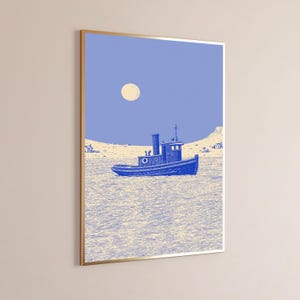 May include: A framed wall art print featuring a blue tugboat centered on a textured light-colored sea. The background shows a pale sky with a round moon and a distant shoreline with small buildings, rendered in a monochromatic blue and cream palette.