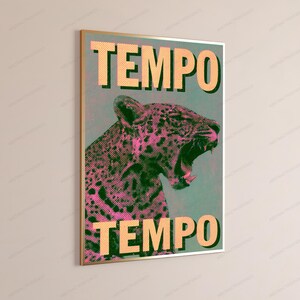 May include: A rectangular wall art print featuring a stylized leopard with its mouth open, rendered in pink and dark green halftone dots against a muted background. The word TEMPO is printed in large, bold, light orange capital letters at the top and bottom.