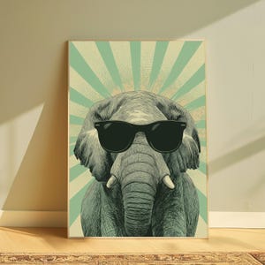 May include: A rectangular wall art print featuring a detailed illustration of an elephant wearing black sunglasses. The elephant is centred against a background of alternating light green and cream-coloured sunburst rays with a dotted texture.