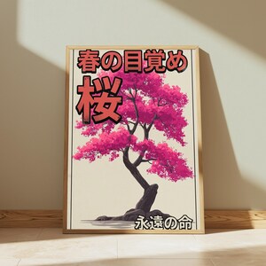 May include: A framed vertical wall art print featuring a stylized dark brown bonsai tree with vibrant pink cherry blossom foliage. The background is a light cream color. Japanese text is printed in black and red at the top and bottom.