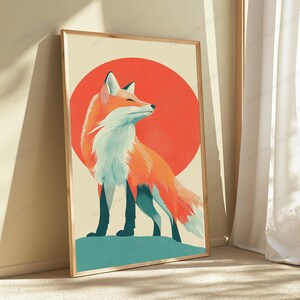 May include: A rectangular framed wall art print featuring a stylised illustration of a fox with orange and white fur standing on a teal ground. Behind the fox is a large solid red circle set against a light cream background within a wooden frame.