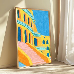May include: A framed art print featuring a vibrant painting of a yellow building with arched blue doorways and a set of pink stairs leading upward. The scene is set against a bright blue sky, rendered with visible, textured brushstrokes throughout.