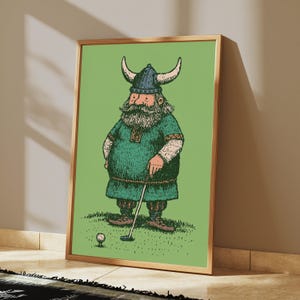 Puede incluir: Una impresi&oacute;n art&iacute;stica enmarcada que presenta una ilustraci&oacute;n de dibujos animados de un vikingo barbudo con un casco con cuernos y una t&uacute;nica verde, de pie sobre un campo de hierba mientras sostiene un palo de golf y se prepara para golpear una pelota.