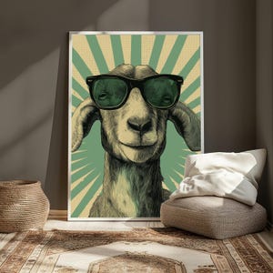 May include: A rectangular wall art print featuring a detailed illustration of a goat wearing large black-rimmed sunglasses. The background consists of a vintage-style sunburst pattern in alternating shades of muted green and cream with a dotted texture.