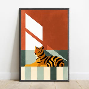 Pu&ograve; includere: Una stampa artistica incorniciata raffigurante una tigre a riposo su una superficie a righe. La tigre &egrave; arancione con strisce nere, posizionata su uno sfondo arancione scuro e verde tenue. Una forma di luce geometrica bianca attraversa la scena.
