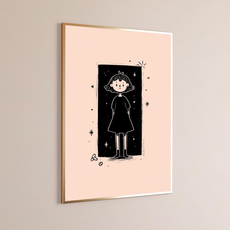 May include: A framed wall art print featuring a black and white line drawing of a person with short hair wearing a dress, centred within a black rectangular block on a pale pink background, surrounded by small star and circle graphic accents.