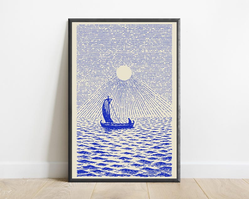 May include: A framed art print featuring a blue ink illustration on a cream background. The image depicts a small sailboat with a single figure on a textured sea under a large sun with radiating lines and a sky filled with horizontal lines.