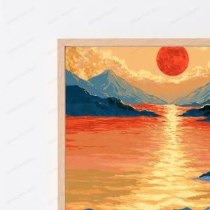 May include: A framed wall art print featuring a landscape illustration with a large red sun setting over a body of water. The scene includes dark blue mountain silhouettes, golden yellow reflections on the water, and orange clouds in the sky.