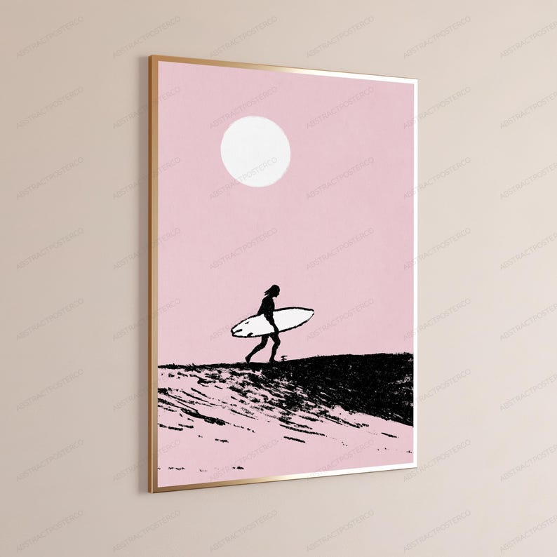 May include: A framed wall art print featuring a silhouette of a person carrying a surfboard across a dark, textured landscape against a solid light pink background with a large white circle representing the sun positioned in the upper center.