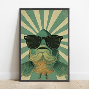 May include: A rectangular wall art print featuring a stylised illustration of a fish wearing black sunglasses. The fish is centred against a background of alternating teal and cream-coloured sunburst rays, creating a bold graphic design.