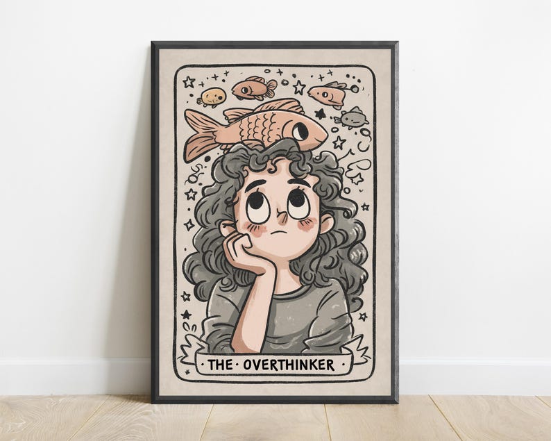 May include: A framed illustration featuring a person with curly dark hair looking upward at a large fish resting on their head. The scene includes smaller fish, stars, and swirls, with a banner at the bottom displaying the text THE OVERTHINKER.