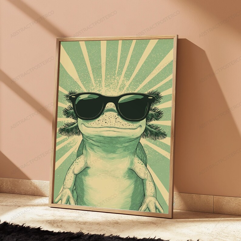 May include: A framed wall art print featuring a light green axolotl wearing black sunglasses. The background consists of a pale yellow and green sunburst pattern radiating from behind the axolotl, creating a graphic illustration style.