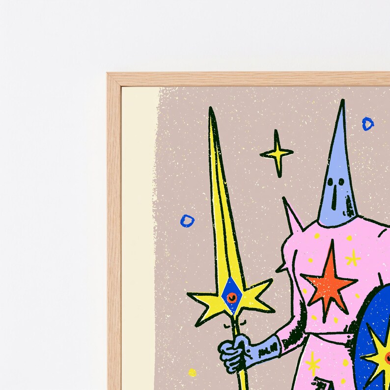 May include: A framed art print featuring a stylised figure in a pink suit with a blue pointed hood, holding a yellow sword with a blue eye detail. The figure is decorated with orange and yellow stars against a textured light brown background.