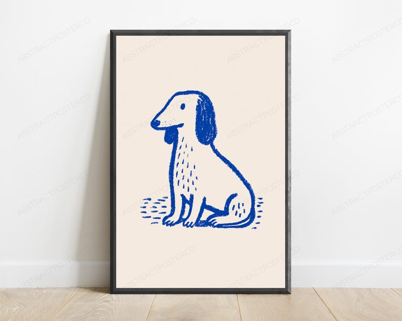 May include: A framed wall art print featuring a blue line drawing of a sitting dog on a light beige background. The dog illustration has a textured, hand-drawn appearance with simple features, including floppy ears and a small tail, set against a plain backdrop.