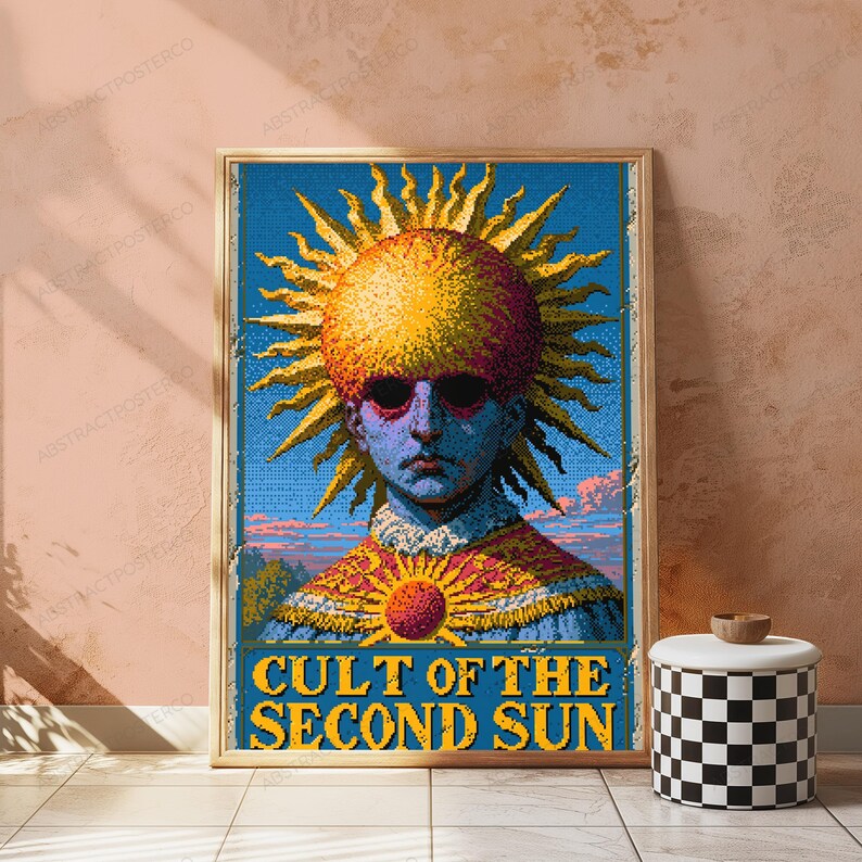 May include: A rectangular wall poster featuring a pixelated illustration of a figure with a large, glowing yellow sun head, dark eyes, and a patterned collar. The text CULT OF THE SECOND SUN is printed in yellow at the bottom against a blue background.