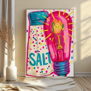 May include: A colorful wall art print featuring a stylized salt shaker with blue text and multicolored dots next to a vibrant pink light bulb with yellow rays and small stars. The illustration uses bold outlines and bright hues to create a graphic design.