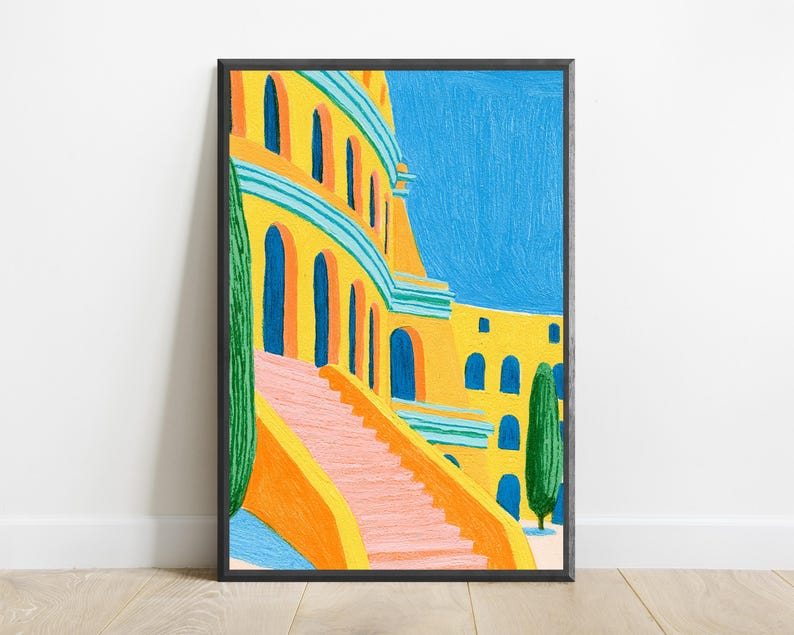 May include: A framed art print featuring a vibrant painting of a yellow building with arched windows and a pink staircase. The scene includes tall green cypress trees against a bright blue sky, rendered with visible brushstrokes and bold colours.