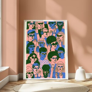 May include: A framed art print featuring a dense crowd of stylised figures in blue and green tones against a light pink background. The figures wear various glasses and accessories, with some holding drinks, rendered in a flat, graphic illustration style.
