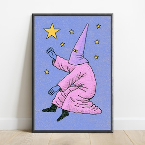 May include: A framed art print featuring a figure in a pink robe and a pointed hood with a single eye, reaching toward yellow stars against a textured light blue background. The figure has blue hands and black feet, rendered in a graphic illustration style.