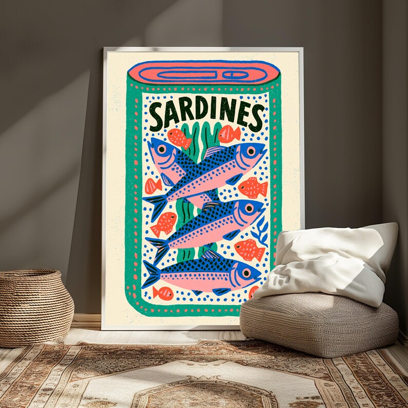 May include: A rectangular wall art print featuring a stylized illustration of a sardine tin. The design includes three large blue and pink fish, several smaller orange fish, and green seaweed accents on a cream background with the word SARDINES.